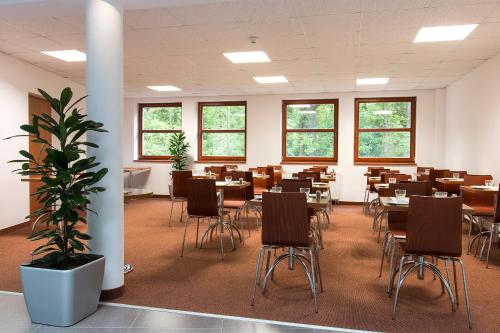 Habitación grande con mesas y sillas. en Sporthotel Hostivice, en Hostivice