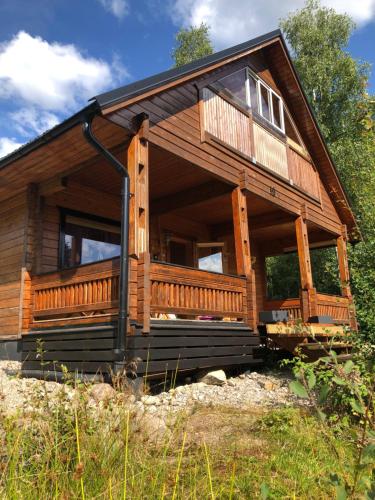 a large wooden cabin with a large deck at Chalet Holmen in Uddevalla