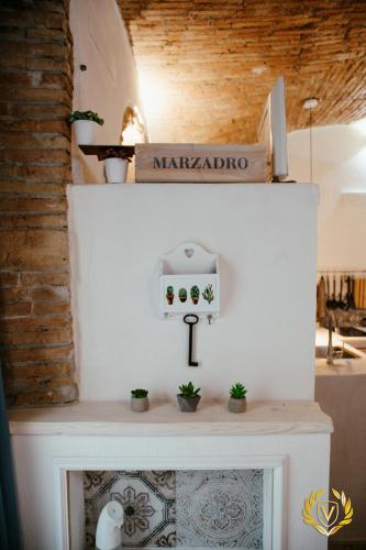 a white fireplace with plants on top of it at VenuSuite VENOSA - Luxury House, Spa & Relax - in Venosa