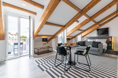 a living room with a bed and a table and chairs at Portas do Céu Apartments in Lisbon