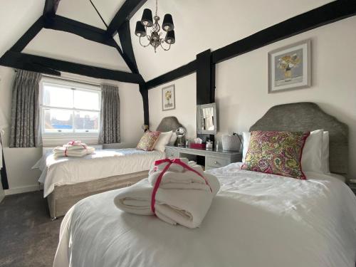 1 dormitorio con 2 camas y lámpara de araña en Purlins Holiday Apartment en Salisbury