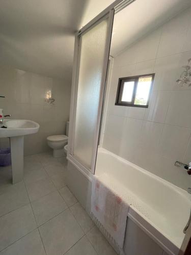 uma casa de banho com uma banheira, um WC e um lavatório. em Hostal Restaurante Luz de Luna em Vilanova de Arousa