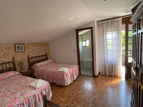 Habitación de hotel con 2 camas y ventana en Hostal Restaurante Luz de Luna, en Villanueva de Arosa