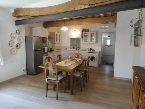 une cuisine avec une table et des chaises en bois dans l'établissement LOlivier sur le Toit, à LʼIsle-sur-la-Sorgue