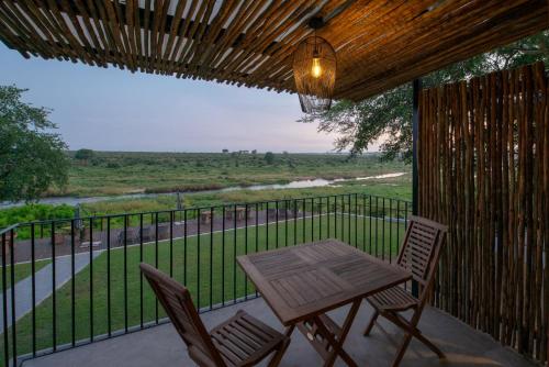 a patio with a table and chairs on a balcony at Buckler's Africa Lodge Kruger Park in Komatipoort