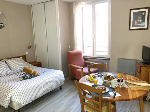 Zimmer mit Bett und Tisch mit Frühstück in der Unterkunft Résidence Thalassum in Bourbonne-les-Bains