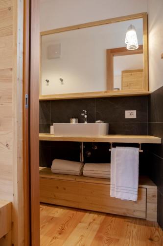 a bathroom with a sink and a mirror and towels at Chalet del Capriolo in Vodo Cadore