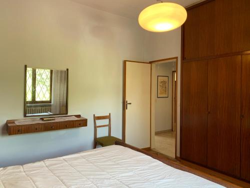 una camera con letto, scrivania e specchio di La casina del sole a Marina di Pietrasanta