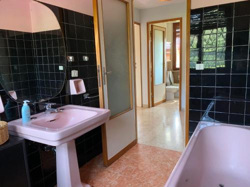 un bagno con un lavandino, una vasca e uno specchio di La casina del sole a Marina di Pietrasanta