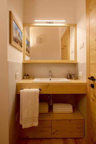 a bathroom with a sink and a mirror and towels at Chalet del Capriolo in Vodo Cadore