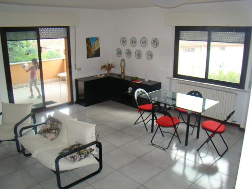 ein Wohnzimmer mit einem Sofa, einem Tisch und Stühlen in der Unterkunft Appartamento Sirolo in Sirolo