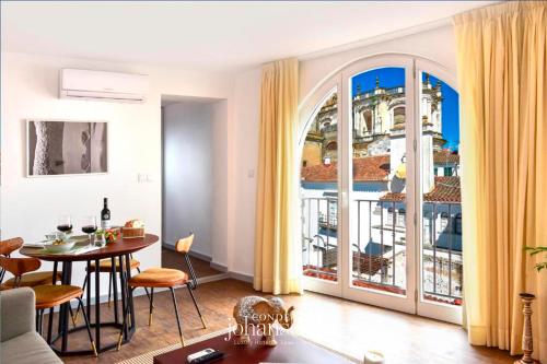a living room with a table and a balcony at The Noble House - by Unlock Hotels in Évora
