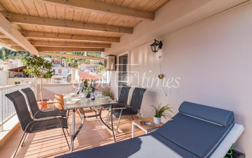 uma sala de jantar com uma mesa e cadeiras numa varanda em Ven Luxury Apartment em Zakynthos