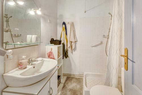 une salle de bain blanche avec un lavabo et une douche dans l'établissement Cyrnos, à La Ciotat