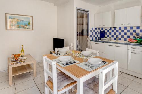 une cuisine avec une table en bois et une salle à manger dans l'établissement Cyrnos, à La Ciotat