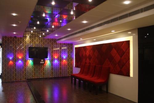 Cette chambre dispose de fauteuils rouges et d'une télévision à écran plat. dans l'établissement Hotel Golden sky, à Lucknow