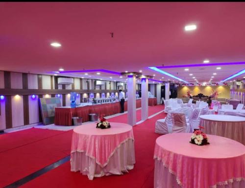a banquet hall with white tables and white chairs at Hotel Golden sky in Lucknow