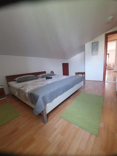 a bedroom with a bed and two green rugs at Bougenville in Kampor