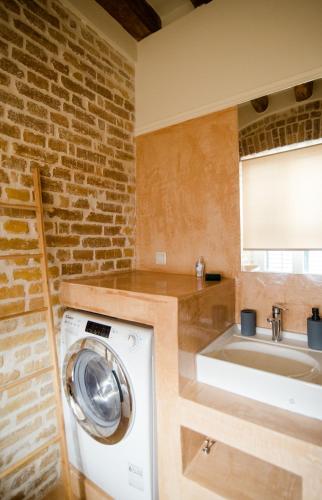 a bathroom with a washing machine and a sink at Curcumelli Luxury Suites - Κorkira in Corfu