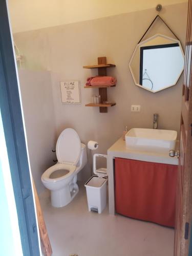 a bathroom with a toilet and a sink and a mirror at Casa Vistas del Rio in Sámara