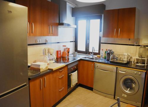 une cuisine avec des placards en bois et un appareil en acier inoxydable dans l'établissement Batalhoz House Bed & Breakfast, à Cartaxo