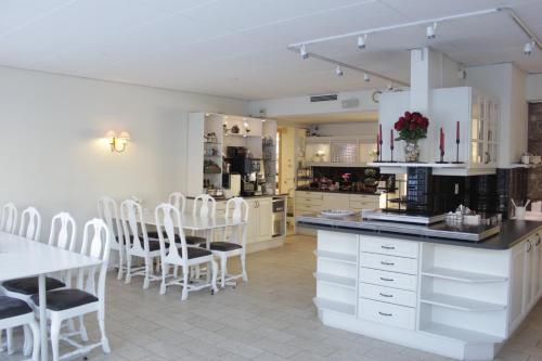 a kitchen with white cabinets and a table and chairs at Hotel Mölndals Bro in Mölndal