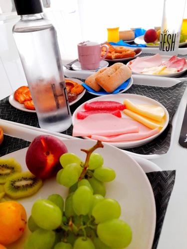 a table topped with plates of food with grapes and fruit at B&B Secret Suite in Gallipoli