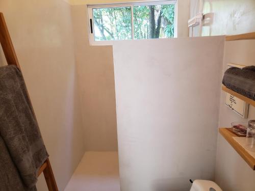 a small bathroom with a window in the corner at Casa Vistas del Rio in Sámara