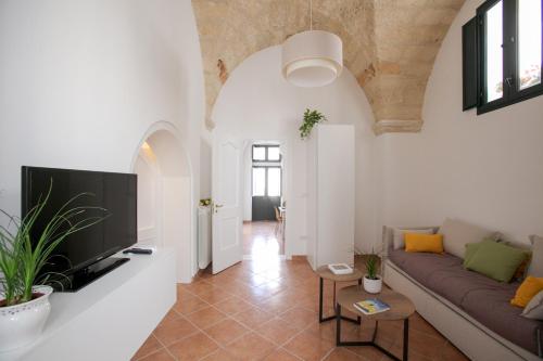 een woonkamer met een bank en een tv aan de muur bij Giulia's House in Galatina