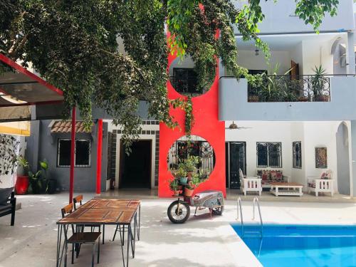 a scooter parked in front of a building with a pool at Loman Art in Dakar