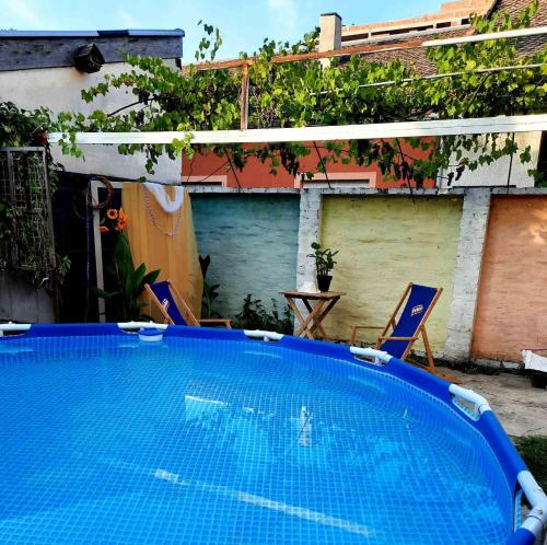 a large blue swimming pool with two lawn chairs at Sunshine house in Pančevo