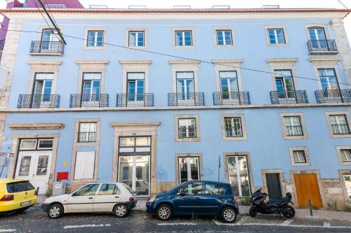 リスボンにあるPortas do Céu Apartmentsの車が目の前に停まった青い建物
