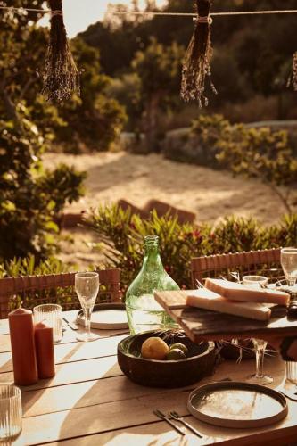 a table with a plate of food and a glass bottle at AF Lindia Nature Design Hotel in Líndos