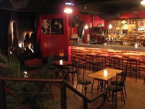 un bar con mesas y sillas en una habitación en Firehouse Hostel, en Austin