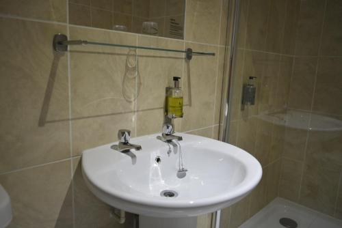 a white sink in a bathroom with a shower at Stallingborough Grange Hotel in Stallingborough