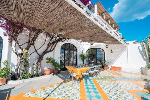 a patio with a table and chairs on a colorful floor at Villa Giusy in Positano
