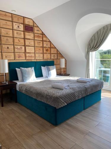a bedroom with a large bed with a blue headboard at Winnica Nawrot in Mechelinki