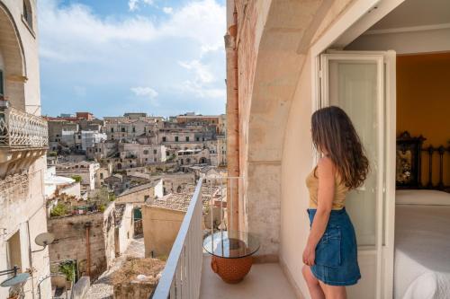 a woman standing on a balcony looking out at a city at La Casa di Ele in Matera