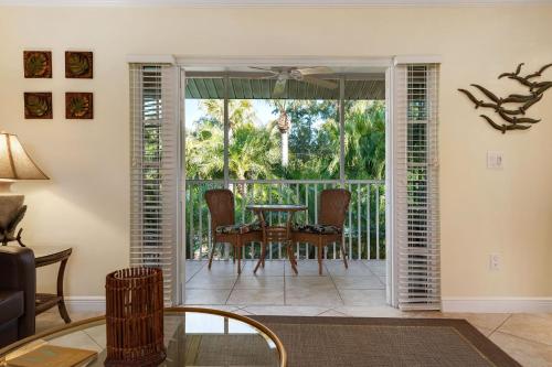 a living room with a table and chairs on a balcony at Siesta Key Inn in Siesta Key