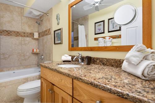 a bathroom with a sink and a toilet and a mirror at Siesta Key Inn in Siesta Key