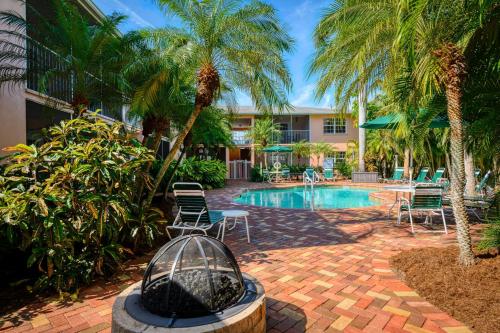a swimming pool with palm trees and a resort at Siesta Key Inn in Siesta Key
