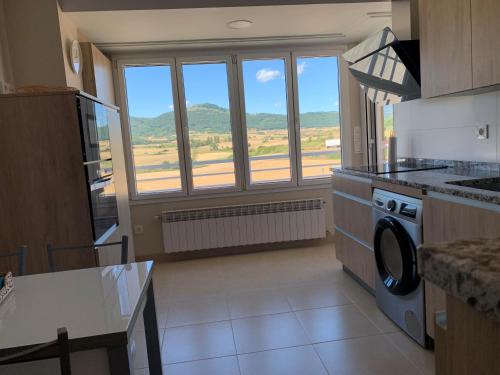 uma cozinha com uma grande janela e uma máquina de lavar louça em Tellazar em Maestu