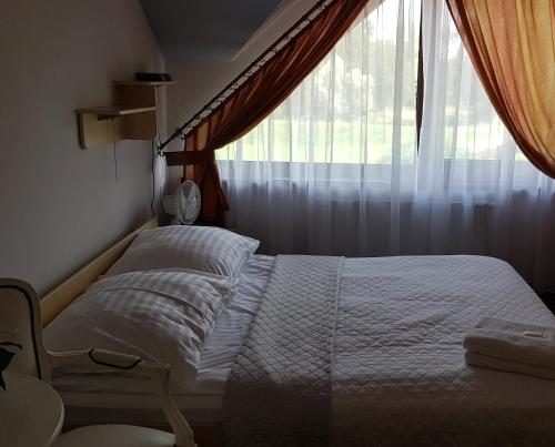 a bedroom with a bed and a window at Hotel Savana in Kłaj