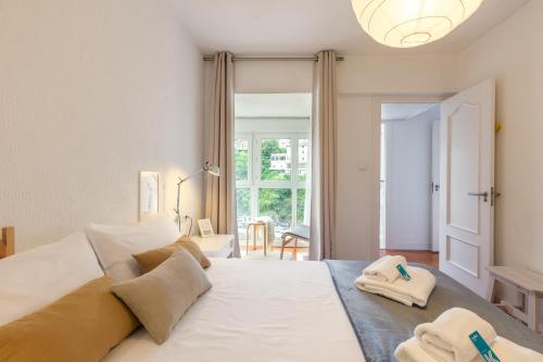 a bedroom with a large white bed with towels on it at Portua - Baskey Rentals in Mutriku