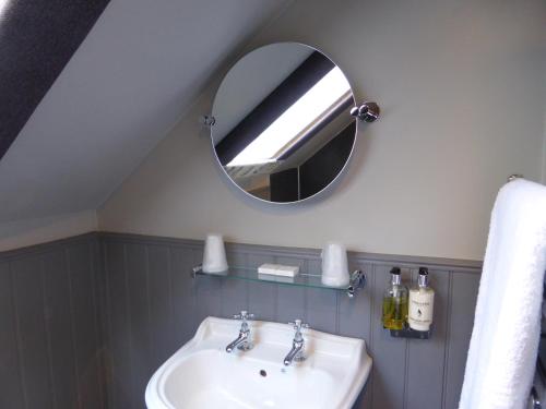 a bathroom with a sink and a mirror at Glen Clova Hotel & Luxury Lodges in Millton of Clova