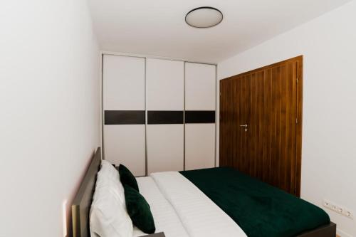 a bedroom with a bed and a wooden cabinet at Homeland Apartments VIVA in Cluj-Napoca