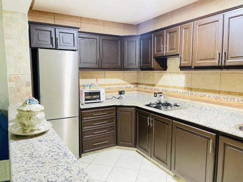 a kitchen with wooden cabinets and a white refrigerator at Laguna City Apartments in Nador