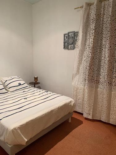 une chambre avec un lit et une fenêtre avec des rideaux dans l'établissement Maison indépendante et familiale en Camargue, à Salin-de-Giraud