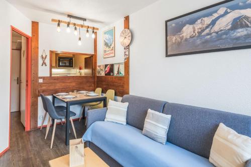 un salon avec un canapé bleu et une table dans l'établissement Appartement Courmayeur - Welkeys, à Chamonix-Mont-Blanc