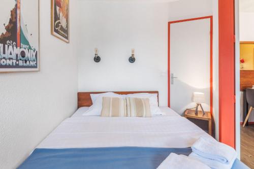 - une chambre dotée d'un lit avec des draps blancs dans l'établissement Appartement Courmayeur - Welkeys, à Chamonix-Mont-Blanc